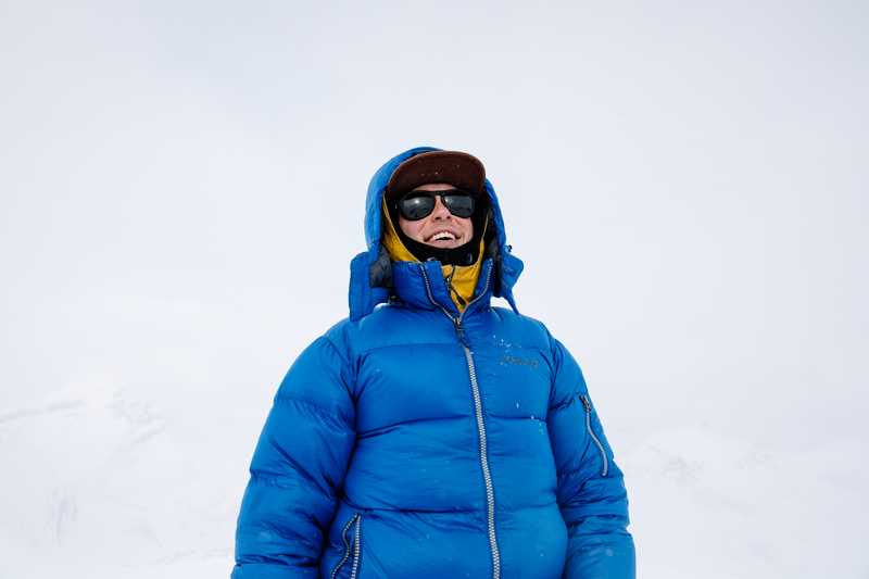 Person in winter environment wearing a puffy parka and sunglasses